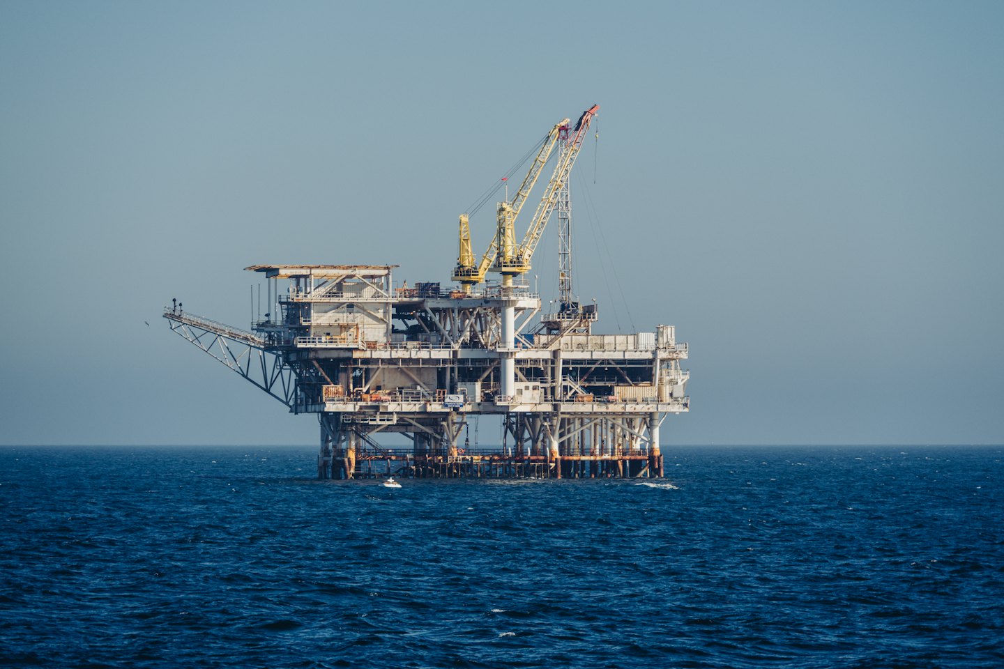 An offshore oil rig stands in the middle of the ocean.