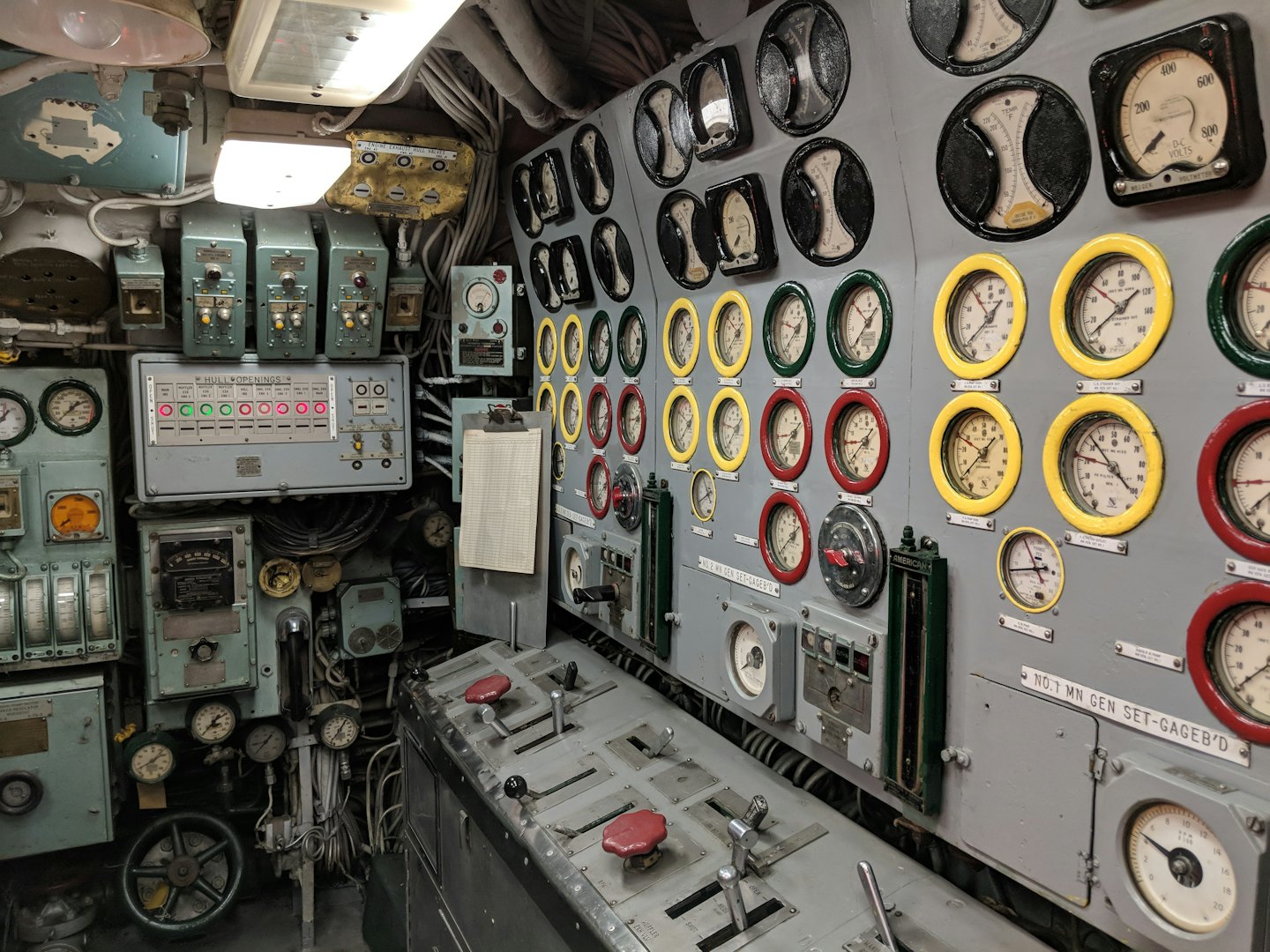 An industrial control room filled with complex dials and switches.
